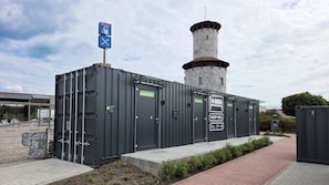 A hostel with multiple rooms, a tower, and a sign indicating a gas station nearby. - Roatel Windischeschenbach A93 (Windischeschenbach)