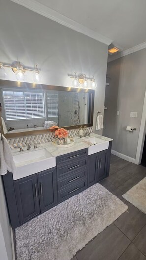 A bathroom with a double vanity, a large mirror, and a lighted vanity area. - Home away from Home - Grill, Patio, Near Lake, Shops & Entertainment, The Colony (The Colony)