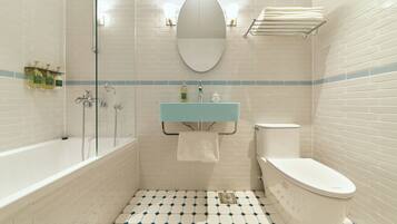 A bathroom with a bathtub, toilet, and a sink with a mirror above.