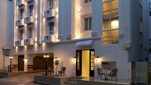 A hotel with a white facade, multiple balconies, and a ground-level entrance with outdoor seating. - Casatel Jeonju Hanok Village (Jeonju)