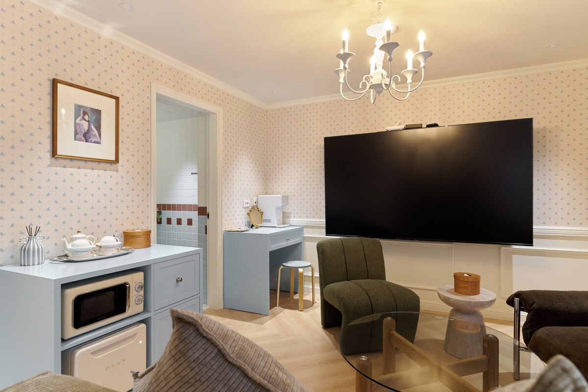 Una sala de estar moderna con una televisión de pantalla plana, un sofá, una mesa de centro y una chimenea.
