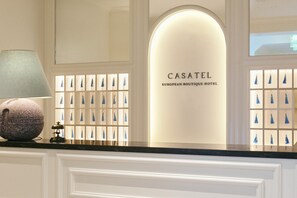 A reception desk with a lamp and a display of keychains.