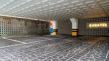 Un espacio interior amplio con piso estampado e iluminación empotrada en el techo.