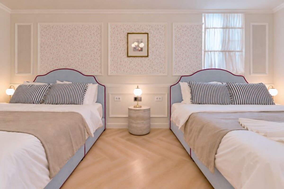 A double bed room with a headboard, bedside tables, and a nightstand.