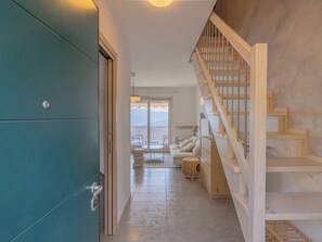 Ein Flur, der zu einer Treppe führt, mit Blick auf Berge.