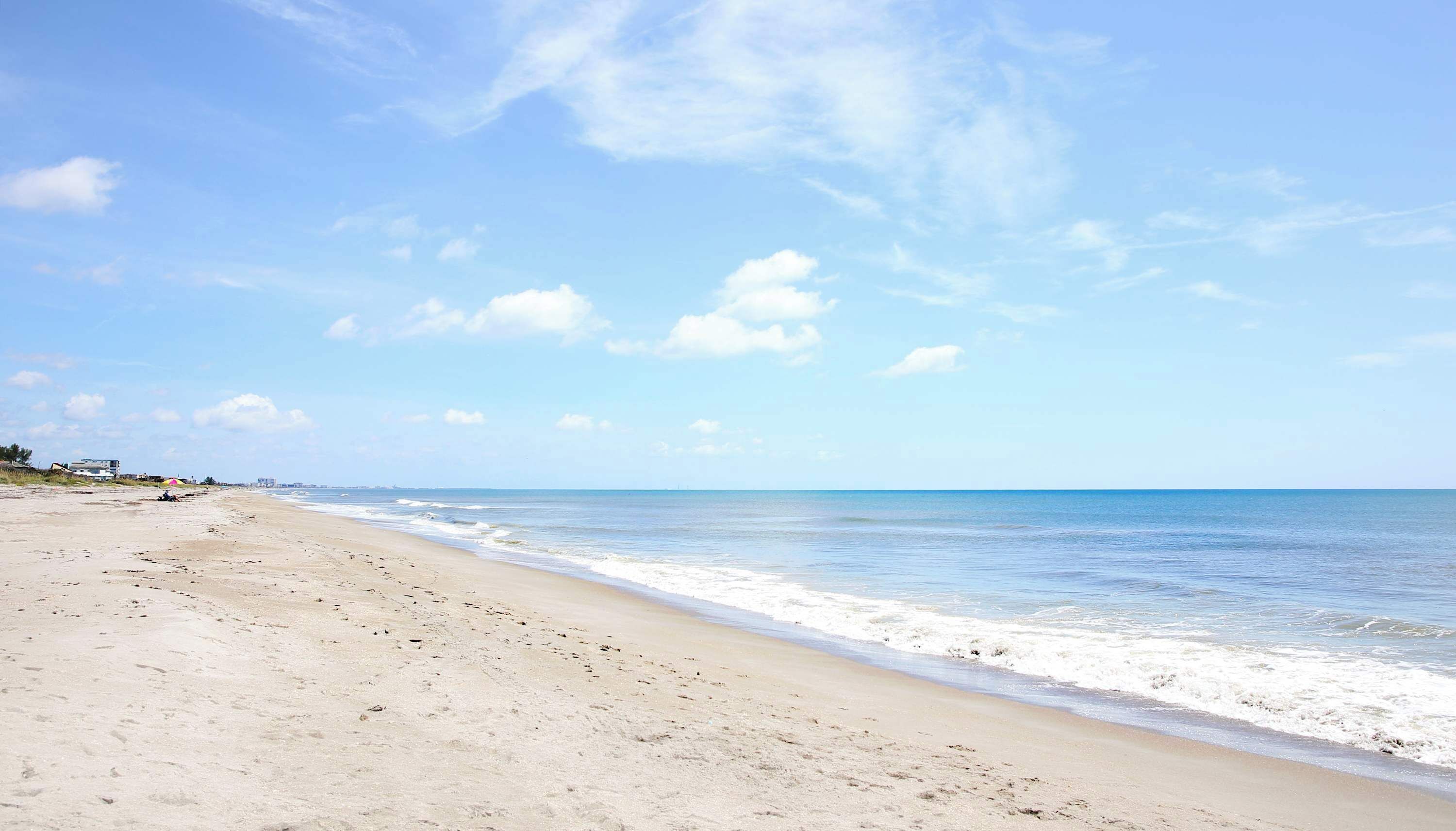 A beach with a clear sky and calm sea.