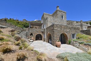 Ein Gebäude aus Stein mit Innenhof, Rundbögen und einer Treppe, die nach oben führt.