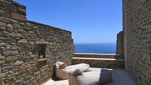 Un espacio al aire libre con paredes de piedra y vista al mar.