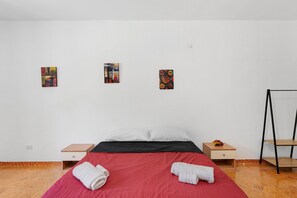 A hotel room with a bed, two bedside tables, a chair, and three artworks on the wall. - Studio '3' with Shared Terrace, Wi-Fi and Air Conditioning (Orgosolo)