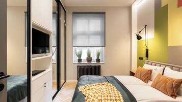 A modern bedroom with a bed, bedside table, and a TV on a stand.
