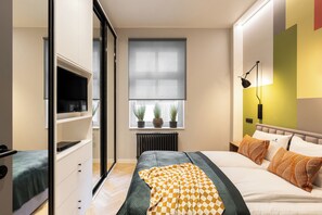 A modern bedroom with a bed, bedside table, and a TV on a stand. - Helska 11 - Apartamenty blisko plaży  (Sopot)