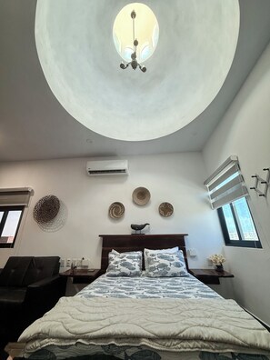 Ein Schlafzimmer mit einem Bett, einer Deckenleuchte, einer Klimaanlage und dekorativen Wandplatten.