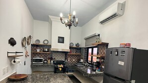 Una cocina con encimeras de granito, un refrigerador negro y una araña.