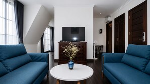 A modern living room with two sofas, a white coffee table, and a flat-screen TV on a wooden cabinet.