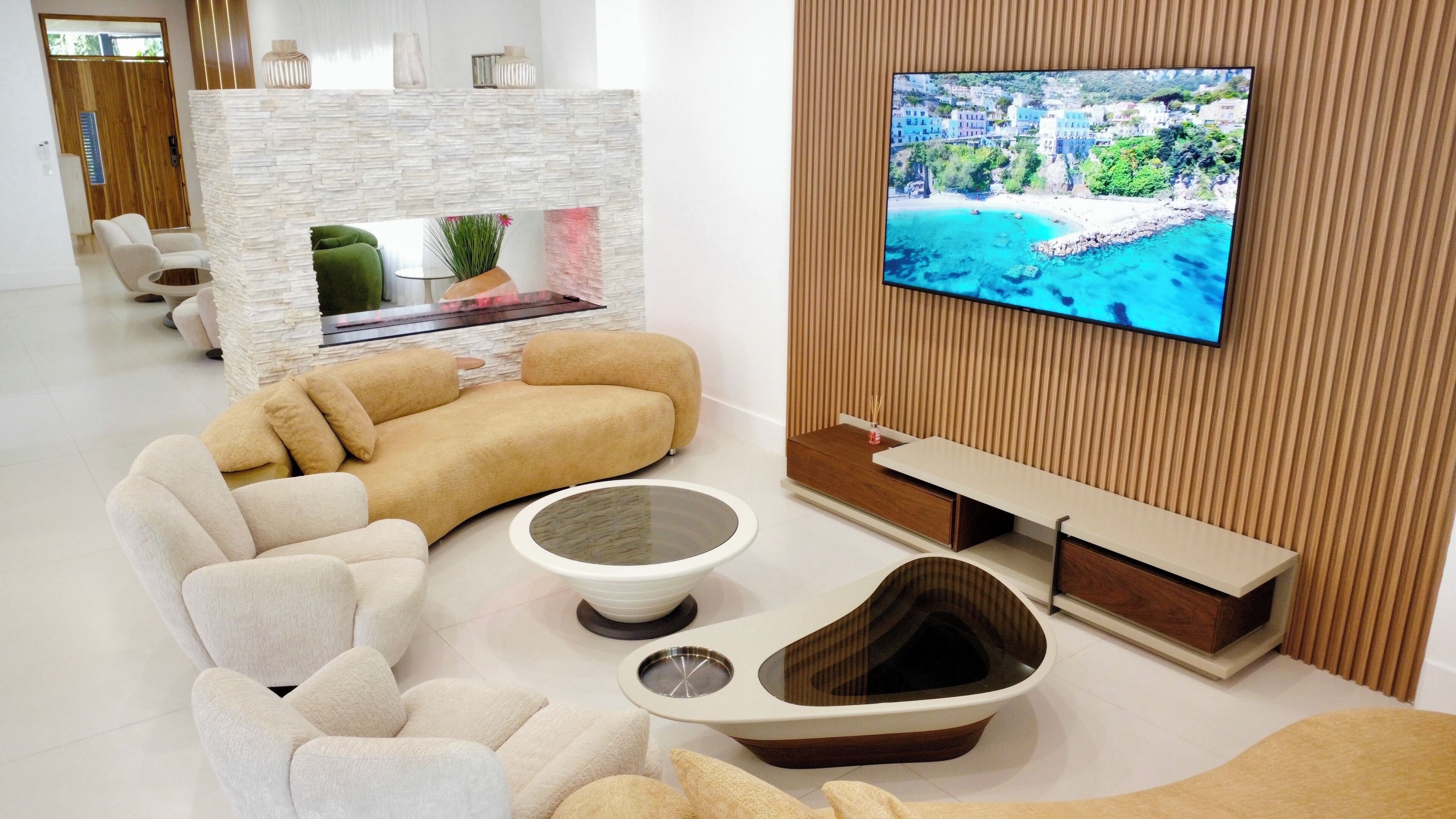 Una sala de estar moderna con un sofá seccional, una mesa de centro y un televisor de pantalla plana montado en una pared de madera.