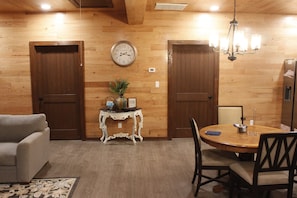 A dining area with a wooden table, chairs, a clock, and a small side table with a plant. - Secluded Cabin Retreat - Fast internet - Fire Pit (Summerville)