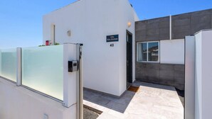 Een modern gebouw met een glazen ingang, een bord met de tekst 'Villa Blue Horizon', en het getal '40' op de muur.