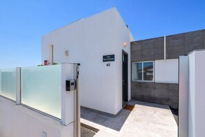 Ein modernes Gebäude mit Glastür, einem Schild mit der Aufschrift 'Villa Blue Horizon' und der Nummer '40' an der Wand.