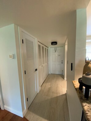 A hallway with white doors, a light switch, and a ceiling light fixture. - Sunsets, sand & Style - Naples Getaway (Naples)