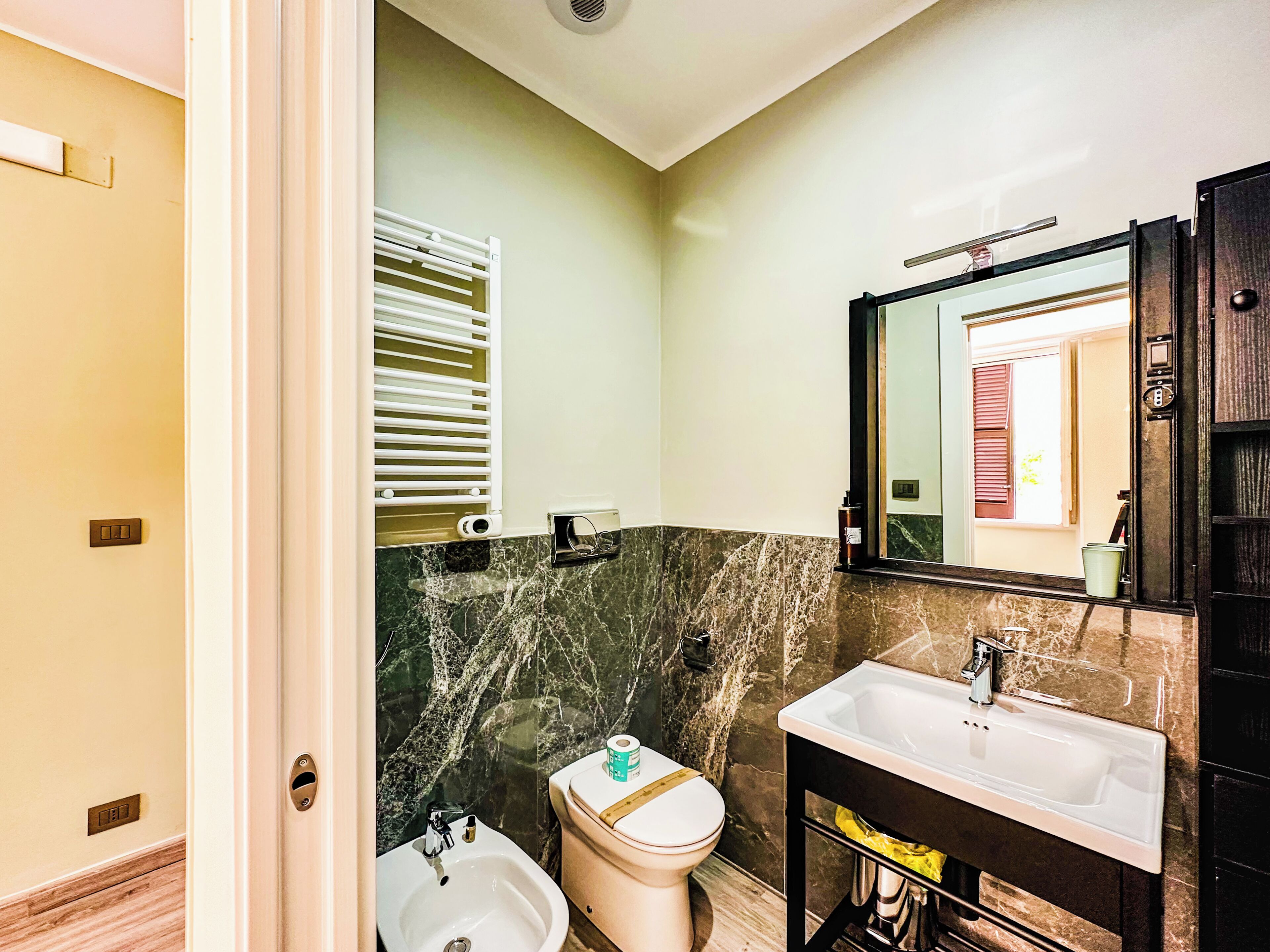 A bathroom with a white sink, a toilet, and a bidet.