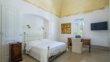 Una camera da letto con un letto, una scrivania, una sedia, un armadio e un quadro appeso al muro.