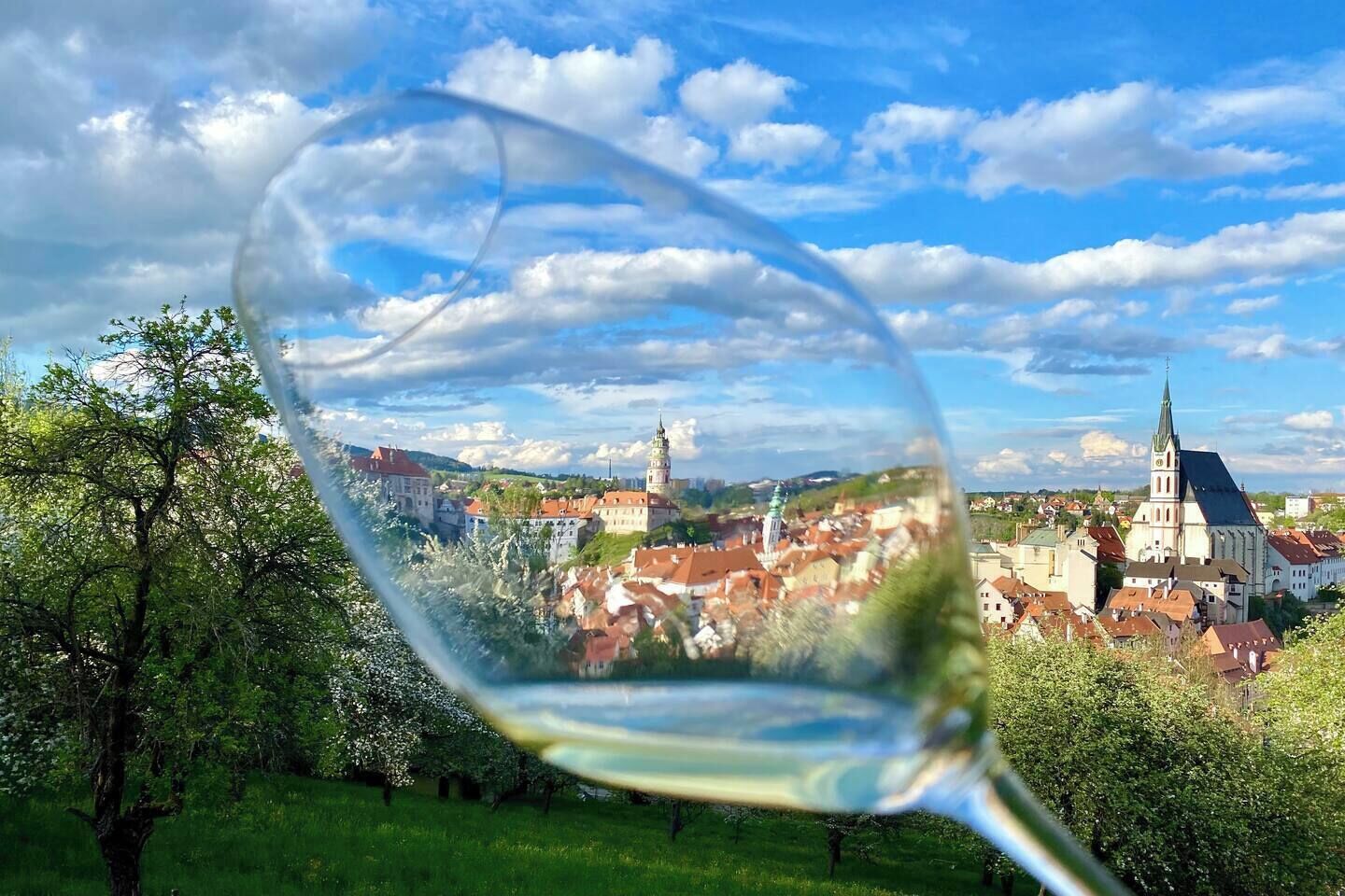 A glass with a view of a town, including buildings and a church.