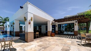 Ein überdachter Außenbereich mit Pool, Sitzgelegenheiten und einer Pergola.