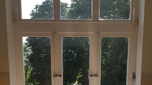 Una cucina con una finestra vista giardino, un lavello e un espositore per piatti.