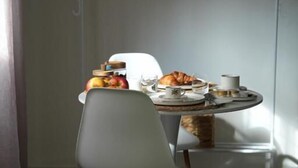 A dining area with a round table, two chairs, and a hanging coat rack. - B&B CasaLù (Sammichele di Bari)