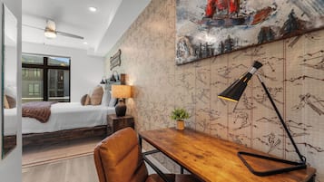 A modern bedroom with a bed, a desk, and a chair.