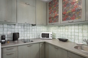Una cocina con microondas, cafetera y tostadora.
