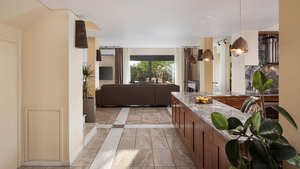 A modern kitchen with a central island, pendant lighting, and a view to the outdoors. - Villa Liberta Athenian Riviera (Saronikos)