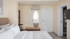 A hotel room with a bed, a bedside table, a mirror, a wardrobe, and a television. - Villa Liberta Athenian Riviera (Saronikos)