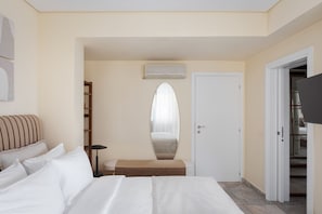 Una habitación de hotel con cama, mesita de noche, espejo, armario y televisor.