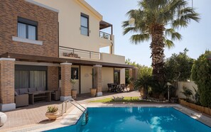 A modern two-story building with a swimming pool, outdoor seating, and a palm tree. - Villa Liberta Athenian Riviera (Saronikos)