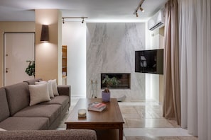 A modern living room with a sofa, coffee table, and a fireplace. - Villa Liberta Athenian Riviera (Saronikos)
