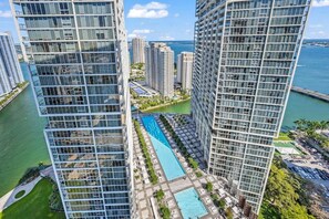 A high-rise building with a swimming pool and a marina in the background. - Icon Brickell 2BR · Panoramic Bay Views, Sleeps 6 (Miami)