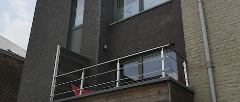 A multi-story building with a balcony on the second floor.