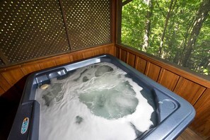 A hot tub with a view of a forest through a wooden partition. - Sugar Bear Smoky Mountain Cabin Getaway (Sevier County)