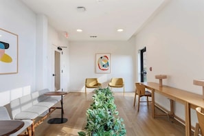 A modern interior with a reception desk, seating area, and a plant centerpiece.