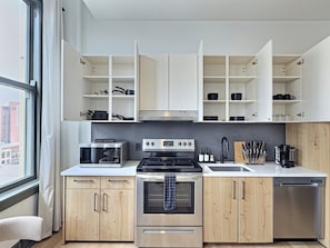 A modern kitchen with a built-in oven, a microwave, and a dishwasher. - Downtown loft near theatres and the ballpark (Birmingham)