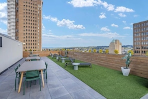 A rooftop terrace with outdoor seating, a view of the cityscape, and a wooden wall. - Downtown loft near theatres and the ballpark (Birmingham)