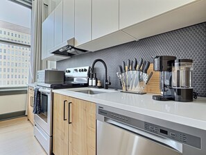 A modern kitchen with stainless steel appliances, a built-in dishwasher, and a knife block. - Downtown loft near theatres and the ballpark (Birmingham)