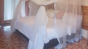 A room with a bed under a canopy, a wooden ceiling, and a window with curtains. - Murchison Falls Coffee Lodge (Purongo)