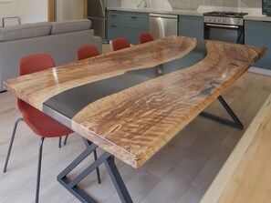 Et moderne spisebord med et unikt trædesign, ledsaget af røde stole.