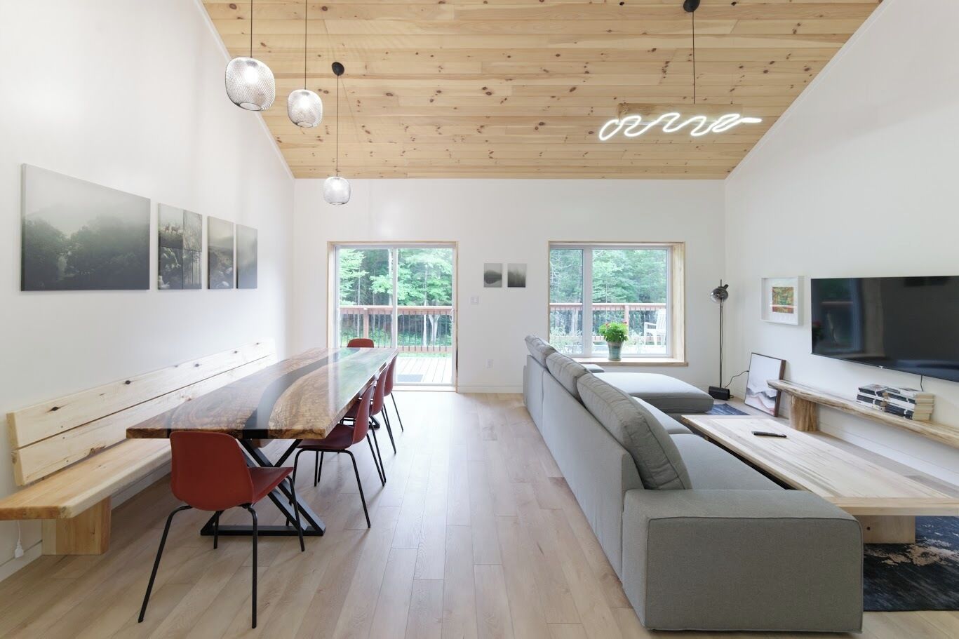 A modern interior with a dining area, seating, and a TV.