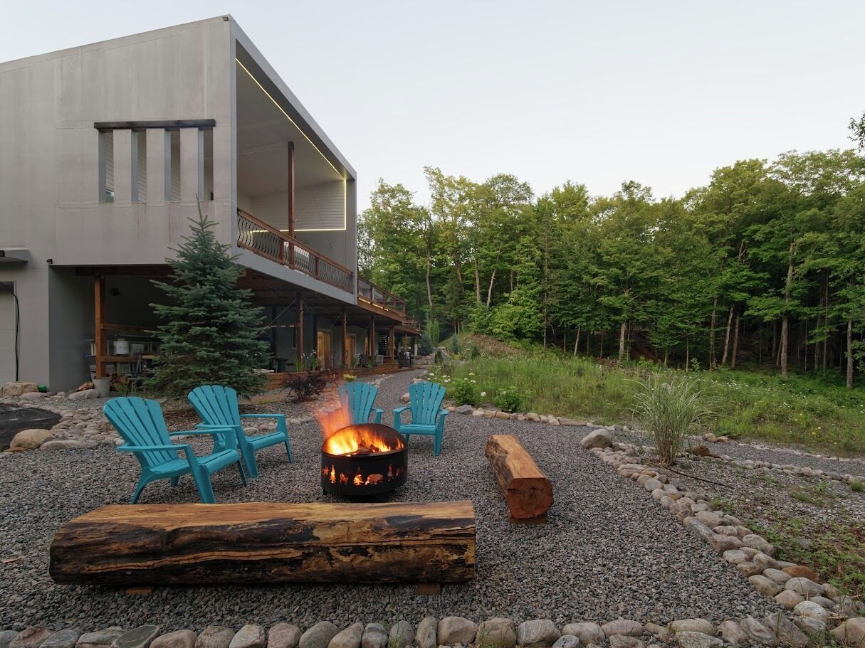 A modern building with a fire pit and outdoor seating.