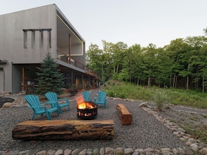 Un bâtiment moderne doté d’un foyer extérieur et de sièges en plein air.