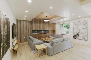Una sala de estar moderna con un sofá gris, una mesa de centro y una chimenea.