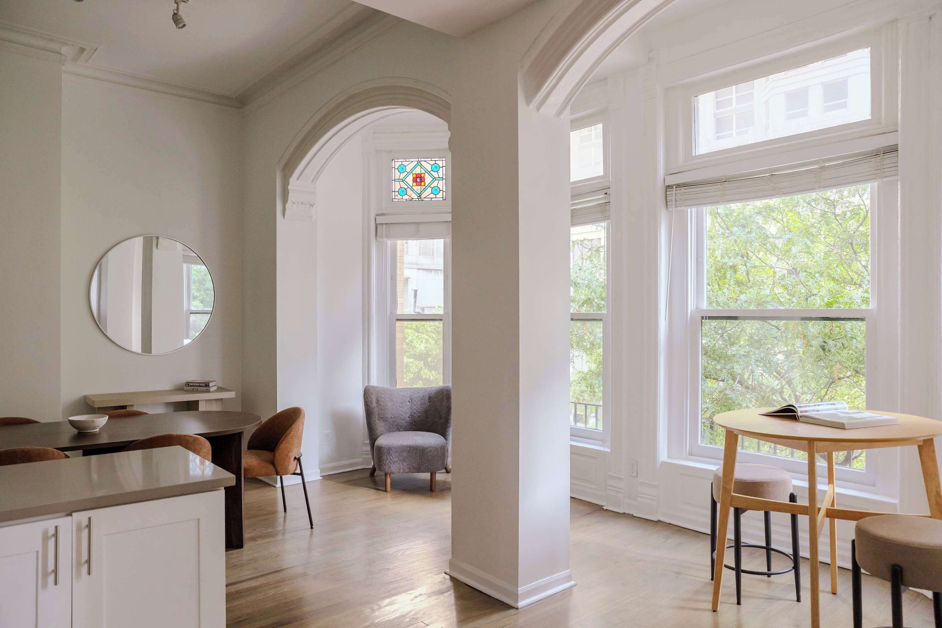 Una habitación amplia con comedor, zona de estar y ventanas grandes que dejan entrar luz natural.